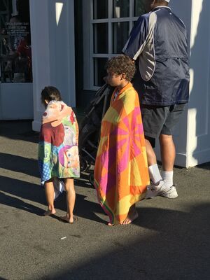 Keywords: pool side,african boy,boys,beach towels,colorful,adult,man,stroller,street,sidewalk,door,window,blue grey jacket,cap