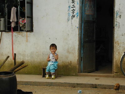 Keywords: boy,baby,door,house,blue outfit,outdoors,seated,wall