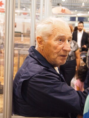 Keywords: old man,seated,inside,blue jacket,talking,white hair,profile