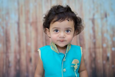 Keywords: portrait,child,kid,girl with a bright blue shirt with gold trim,boy