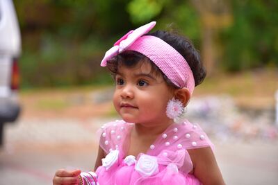 Keywords: baby,pink dess,handband,girl,closeup,flower earrings,3/4 view,outside