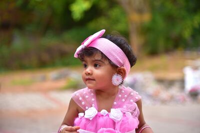 Keywords: baby,pink dress,headband,girl,flower earrings,polka dots,dirt,trees,brown skin