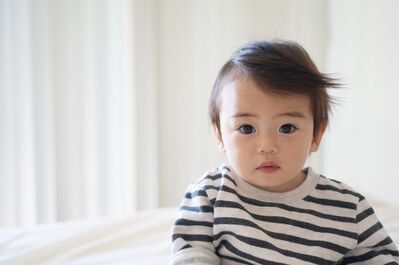 Keywords: boy,portrait,short,dark hair,brown,black and white shirt,white room,background