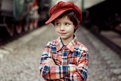 Keywords: boy,child,kid,cap,red,orange,plaid,railroad station,tracks,train,hat