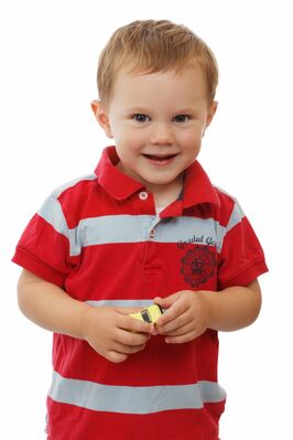 Keywords: boy,child,kid,red striped shirt,yellow truck,toy,smiling,blonde,hair,torso