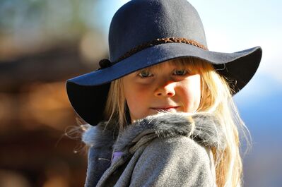 Keywords: girl,blue big hat,blonde hair,grey coat with fur,sunny day