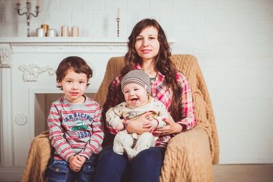 Keywords: family,mom,children,boy,baby,home,yellow throw,chair,brown hair,cap,sitting