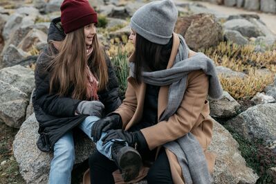 Keywords: two girls,friends,winter,hat,cap,stones,leg,jeans,scarf,beige,coat,outdoors