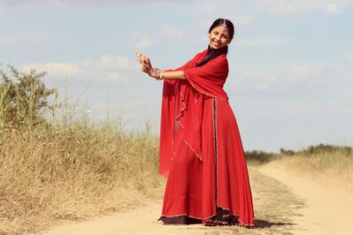 Keywords: girl,woman,youth,young,red,dress,sari,indian,headband,hands,brown grass,sand