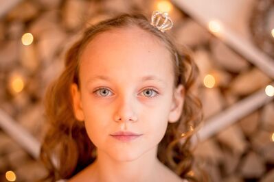 Keywords: girl,kid,child.hairband with tiny crown,lights in background,curly hair