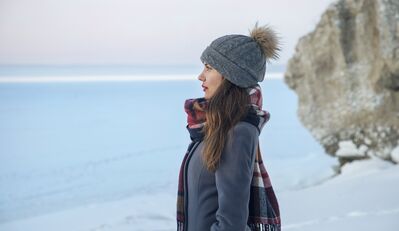 Keywords: girl,woman,youth,young,plaid scarf,grey coat,grey hat with rabbit fur tassel,rock,ocean