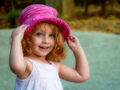 Keywords: girl,closeup,face,pink hat,white dress,green background,arms up,red hair