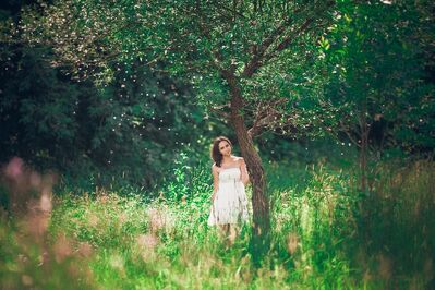 Keywords: girl,woman,youth,young,flowering tree,pink flowers,tall grasses,trees in background,white dress,brown hair