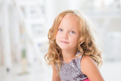 Keywords: girl,white girl,young girl,long curly blonde hair,grey print sleeveless top,pink sash,white background