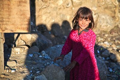 Keywords: portrait,girl,deep shadows,hands on stones,bright sun,sunlight,brown hair,skin,pink top