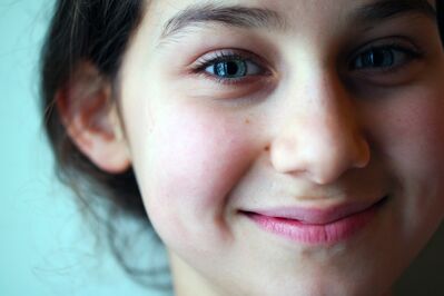 Keywords: closeup,girl,smiling,smile,moles,black hair,light blue background,hair up