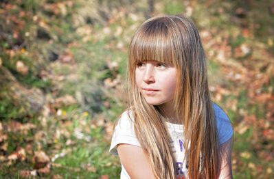 Keywords: portrait,girl,3/4 view,long blonde hair,bangs,outdoors