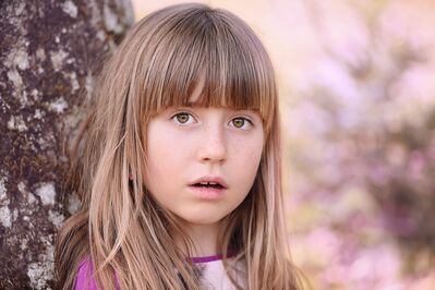 Keywords: portrait,girl,tree trunk,purple and white top,shirt,outdoors,long blonce hair