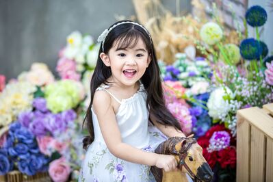 Keywords: child,girl,kid,hobby horse,white and purple dress,headband,long black hair,asian,flowers