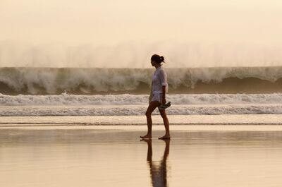 Keywords: beach,ocean,water,woman,sea wall,surf,walking,white top,hair up