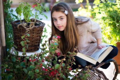 Keywords: little girl,book,sitting,jeans,white top,flowers,straw basket,long hair,barette