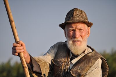 Keywords: man,beard,white,vest,hat,outdoors,elderly,stick