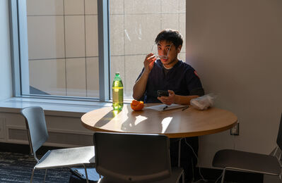 man-student_lobby_holding-eyeglasses
