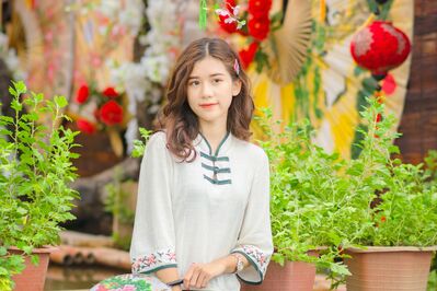 Keywords: girl,white top with mandarin collar,barette,paper lanterns,red,green plants,pots,herbs