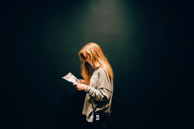 Keywords: girl,eading a magazine,long blondee hair,profile,dark background