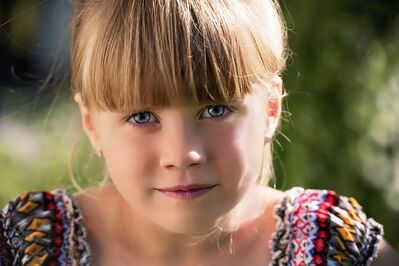 Keywords: portrait,girl,child,blonde,hair,bangs,blue eyes,colorful top,shirt,many colors