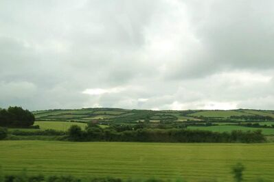 Keywords: green farmland with grey clouds