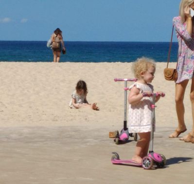 Keywords: girl,beach,bike,mother cell phone,white dress,children,two,women,ocean,hat,backpack,sand,purse