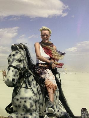 Keywords: girl,hobby horse,merry-go-round,spots,multicolored scarf,sky,clouds,blonde