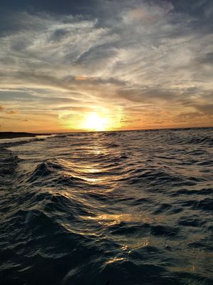 Keywords: sunrise over ocean,waves,dark,sunlight