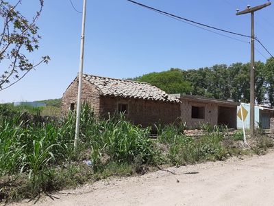 Keywords: adobe house,stone roof,greenery,road,telephone poles